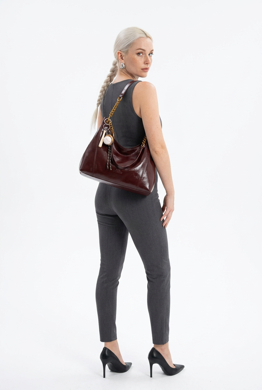 Sac bordeaux à chaîne porté en pose de dos sur fond studio blanc