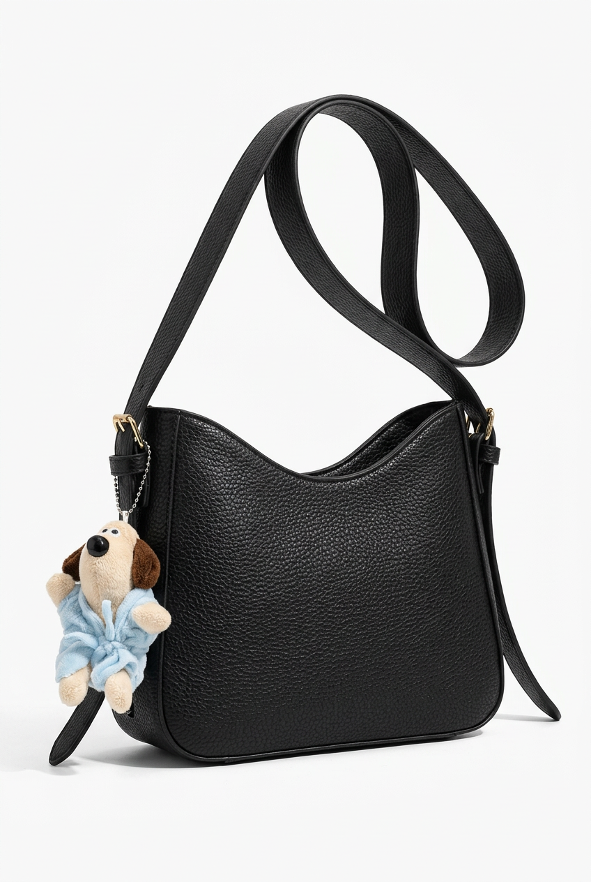 Sac noir seul sur fond studio blanc