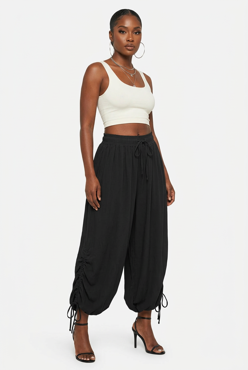 Pantalon noir froncé à cordon porté de trois-quarts