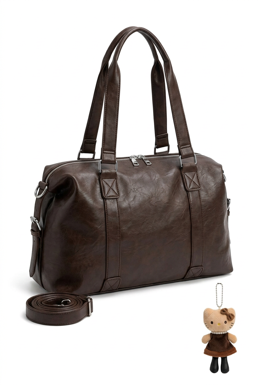 Sac porté épaule marron avec bijou de sac, seul sur fond studio blanc
