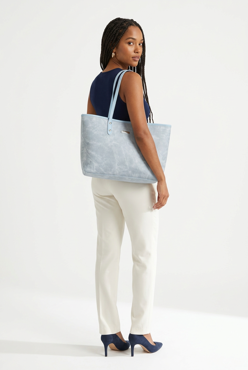 Sac bleu porté en pose de dos, vue corrigée sur fond studio blanc