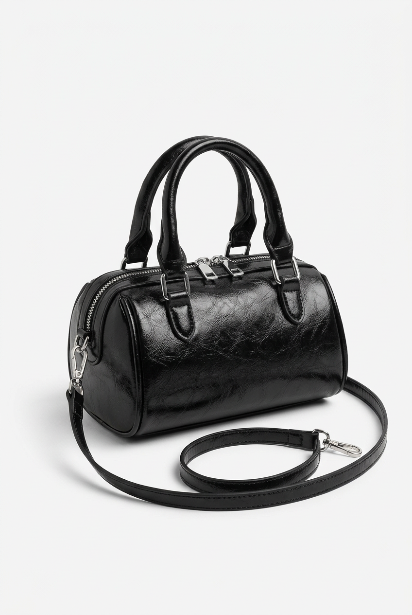 Sac cylindrique noir seul sur fond studio blanc