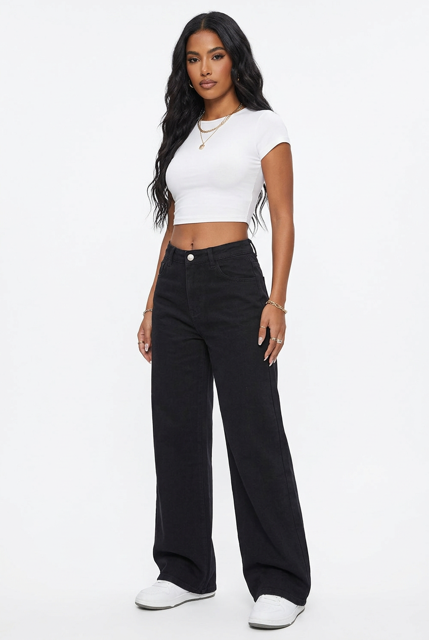 Jean noir large taille haute porté, vue corps entier sur fond studio blanc