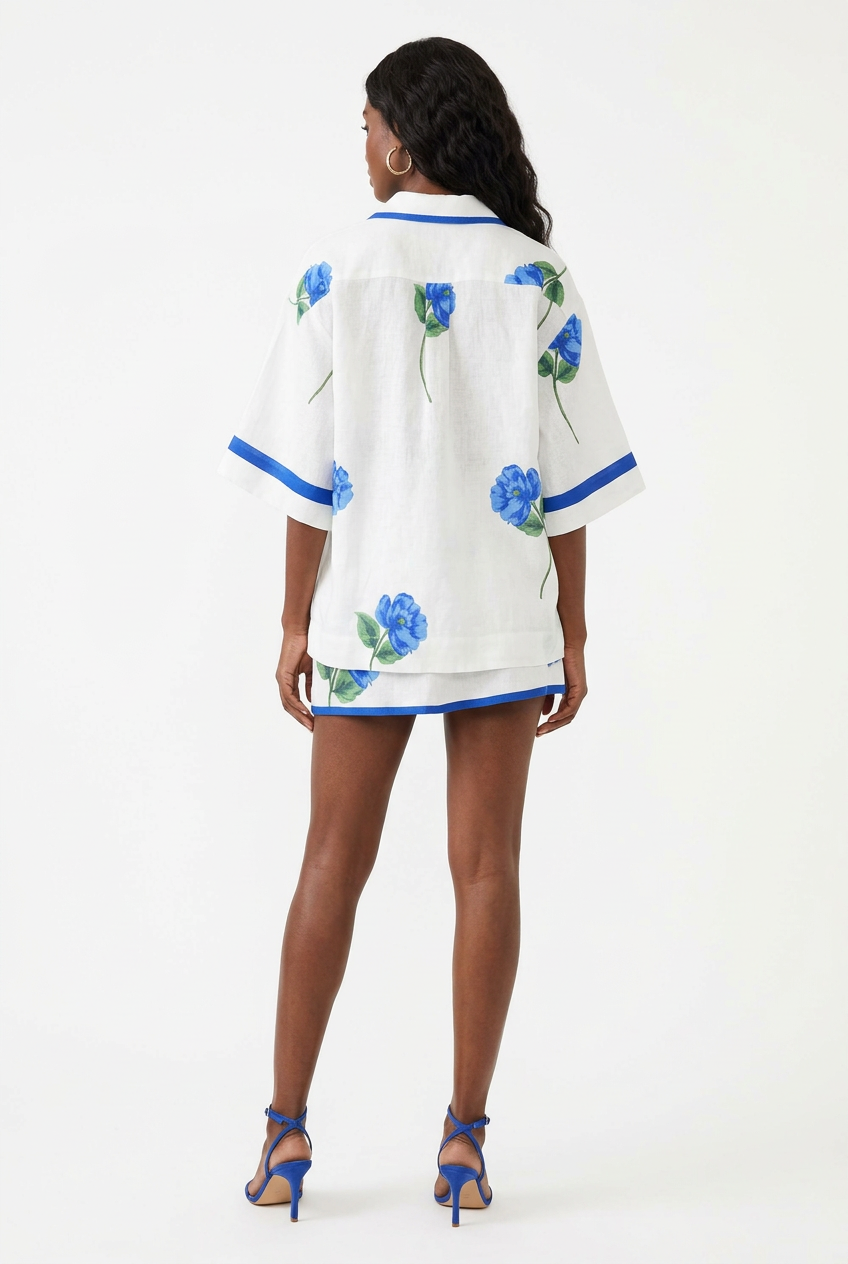 Ensemble chemise fleurie et mini jupe bleu et blanc porté de dos corps entier