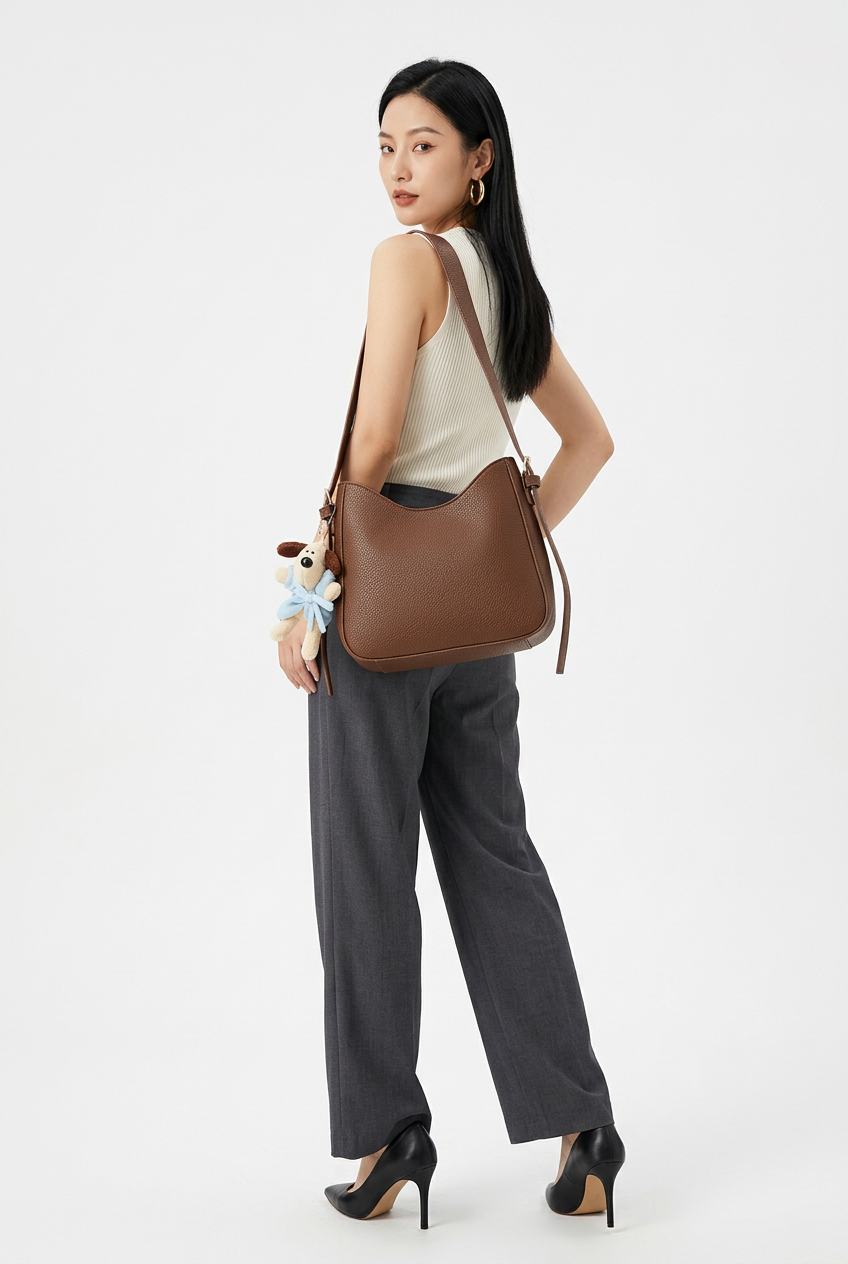 Sac marron porté en pose de dos sur fond studio blanc